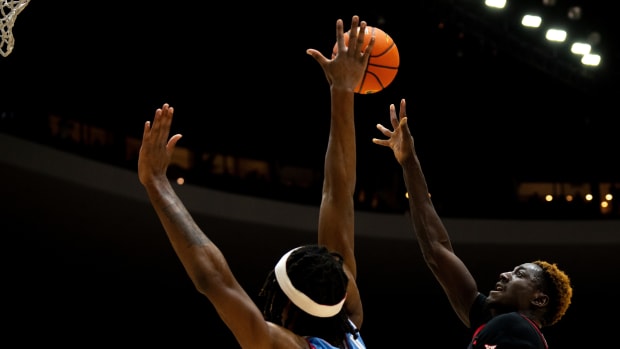 Cincinnati Bearcats forward Aziz Bandaogo (55) shoots around Dayton Flyers forward DaRon holmes II (15) in the second half of the NCAA men's basketball game between the Dayton Flyers and Cincinnati Bearcats at Heritage Bank Center in Cincinnati on Saturday, Dec. 16, 2023.